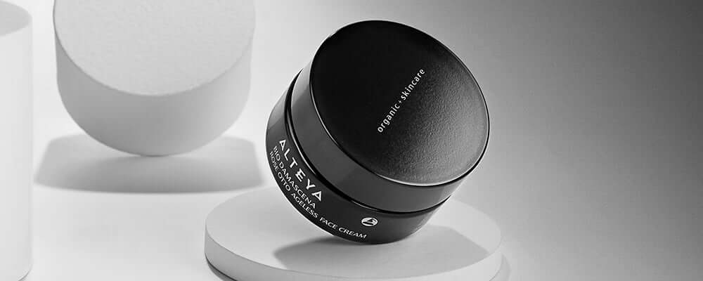 A black and white jar sitting on a white pedestal.