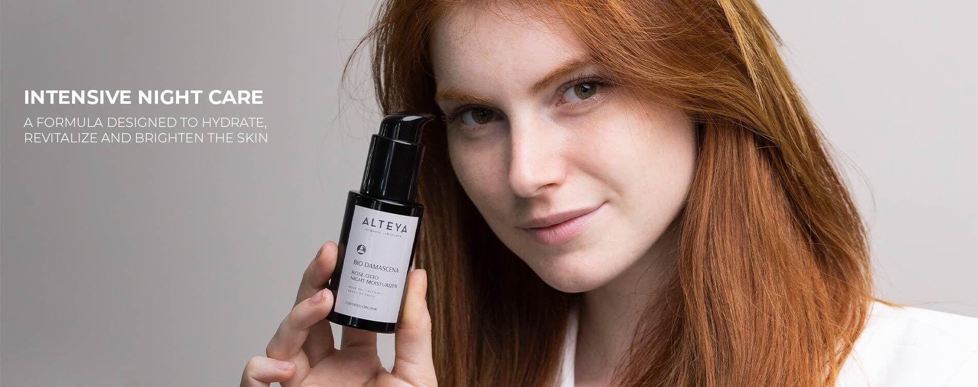 A woman holding up a bottle of eye cream.
