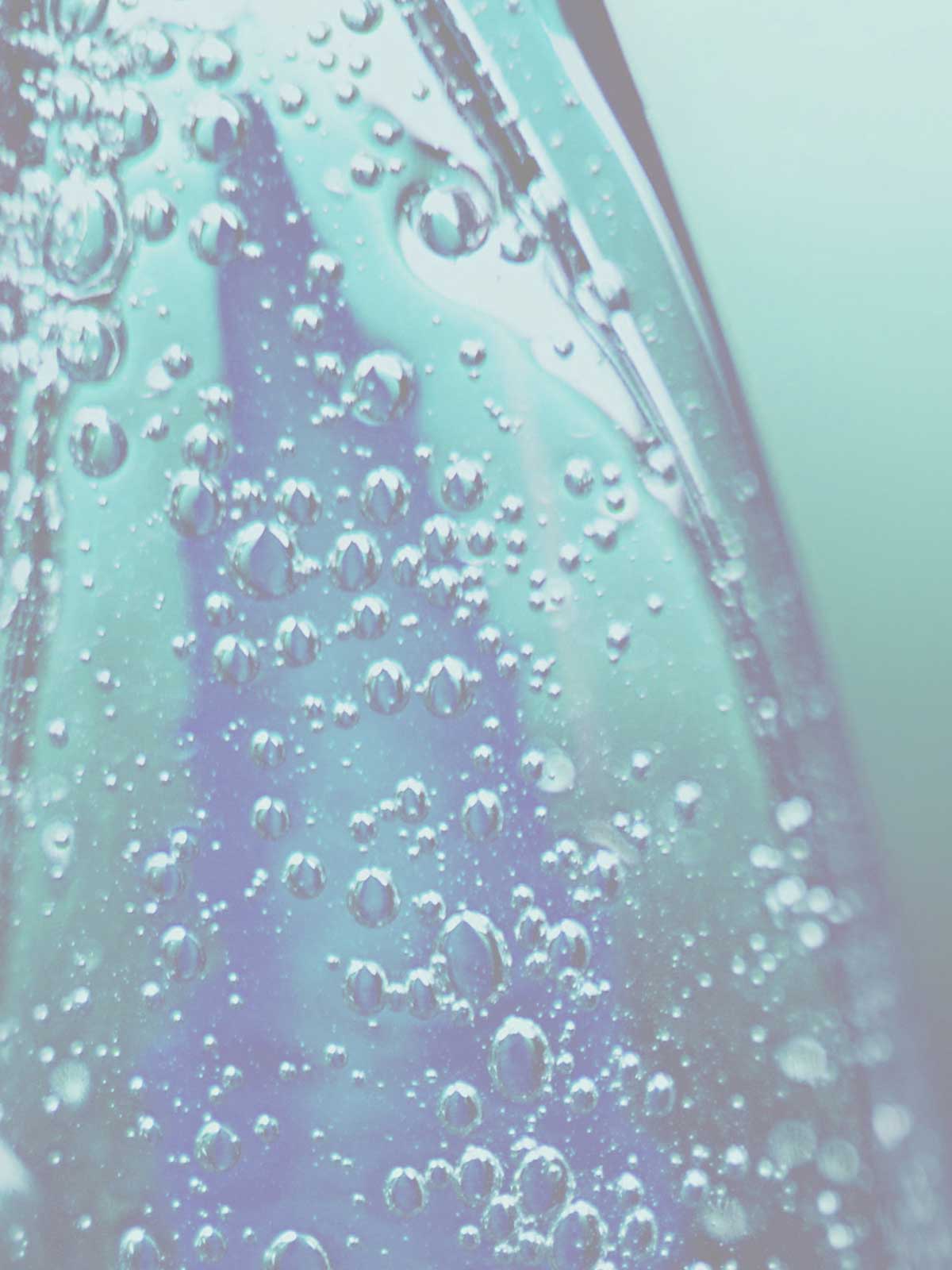 A close up of a bottle with bubbles in it.