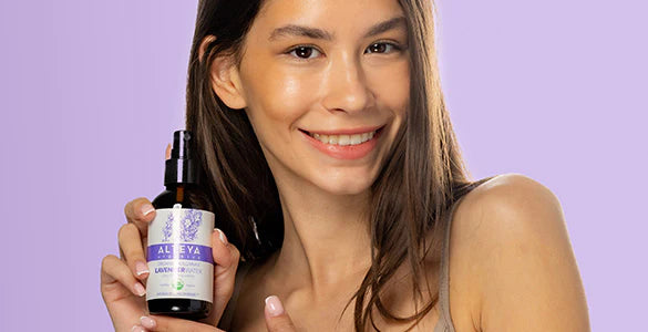 A woman holding a bottle of lavender oil.