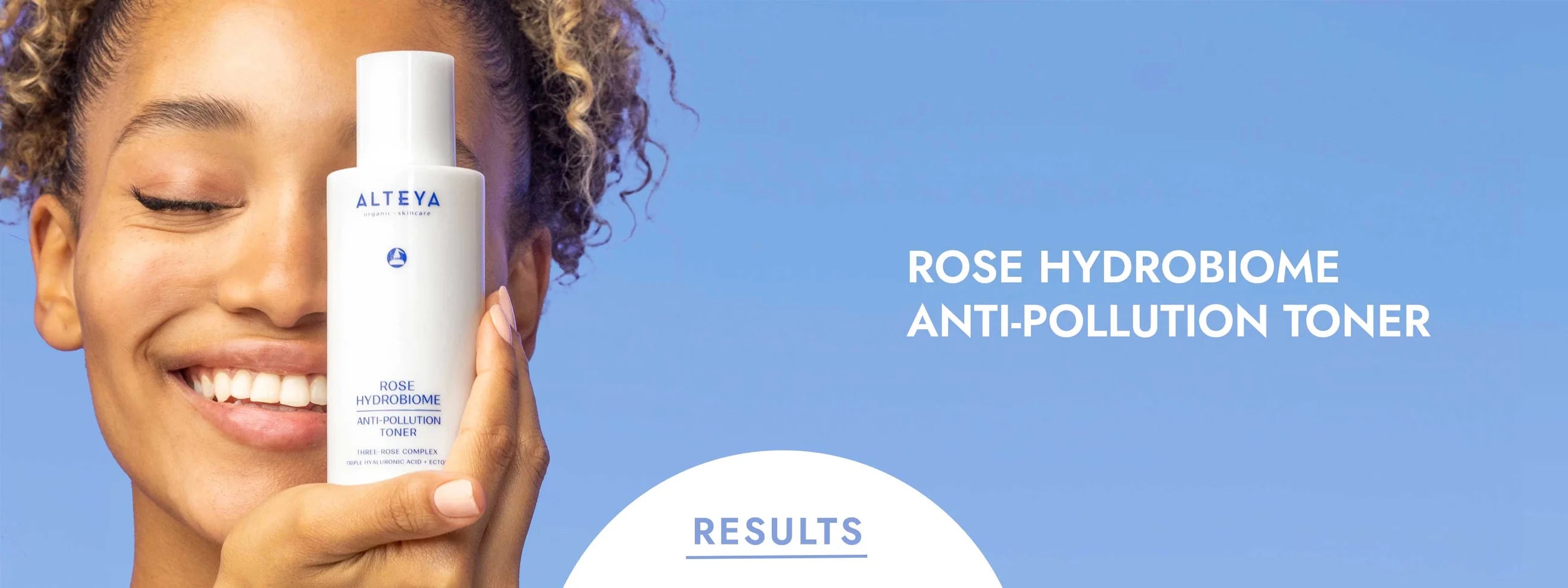 A woman is holding a bottle of rose hydrosoma anti-pollution toner.