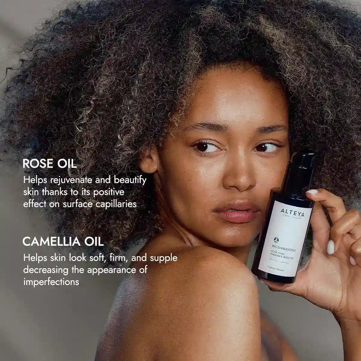 A person holding a bottle of Bio Damascena Rose Otto Radiance Body Oil. Text highlights the luxurious skin treatment with rose oil's benefits for rejuvenating skin and camellia oil's effect on making it look soft and firm while reducing imperfections, creating radiant skin.