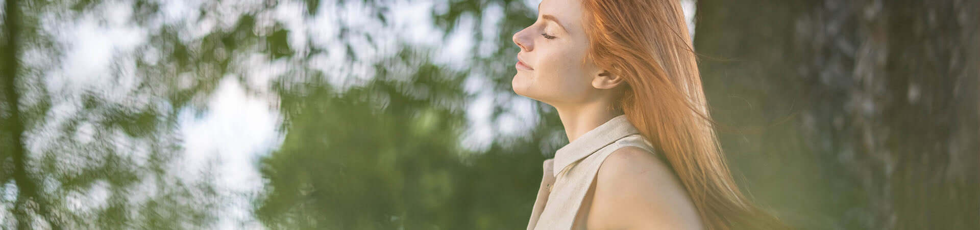 A woman with long red hair is looking at the camera.