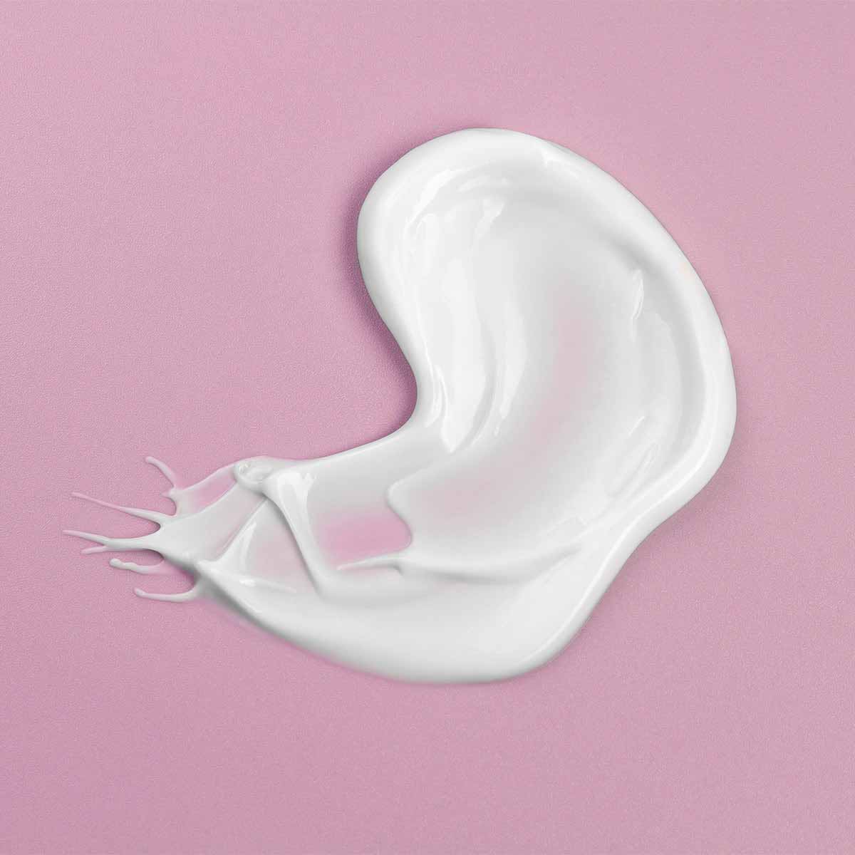 A white Bio Damascena Rose Otto Ageless Face Cream infused with white truffle extract and rose oil on a pink background by Alteya Organics.