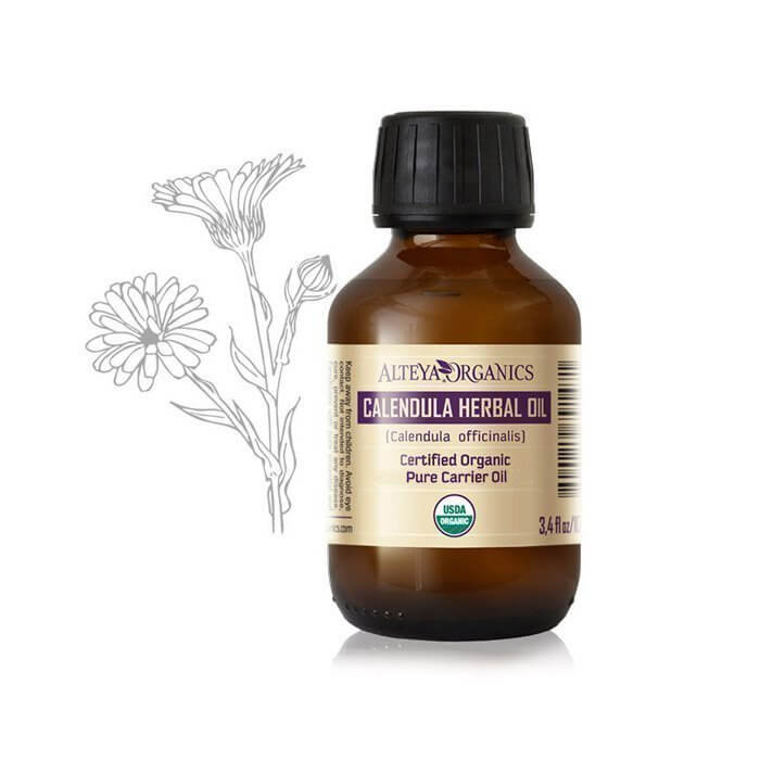 A bottle of Organic Calendula herbal oil from Alteya Organics next to a drawing of a flower, perfect for soothing irritated skin.