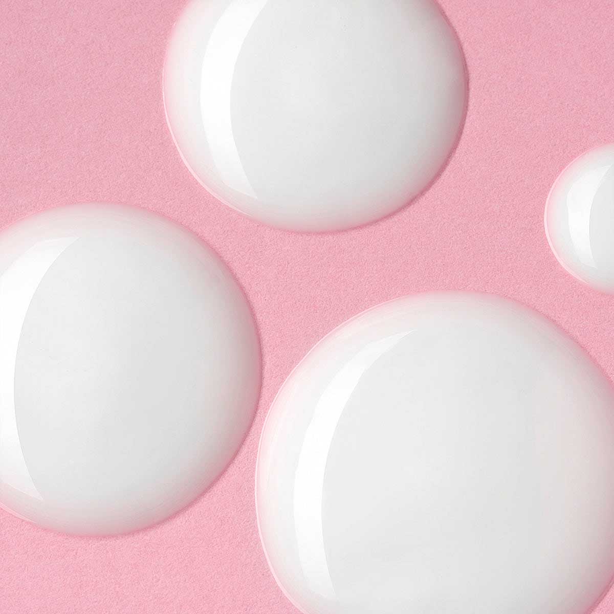 A cluster of white circles on a pink background, reminiscent of the Iridescent Light Serum Luminous Rose by Alteya Organics, a skin hydrating and moisturizing serum.