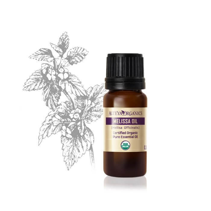 A bottle of Alteya Organics Lemon Balm essential oil (Melissa officinalis - True Melissa) next to a leaf.