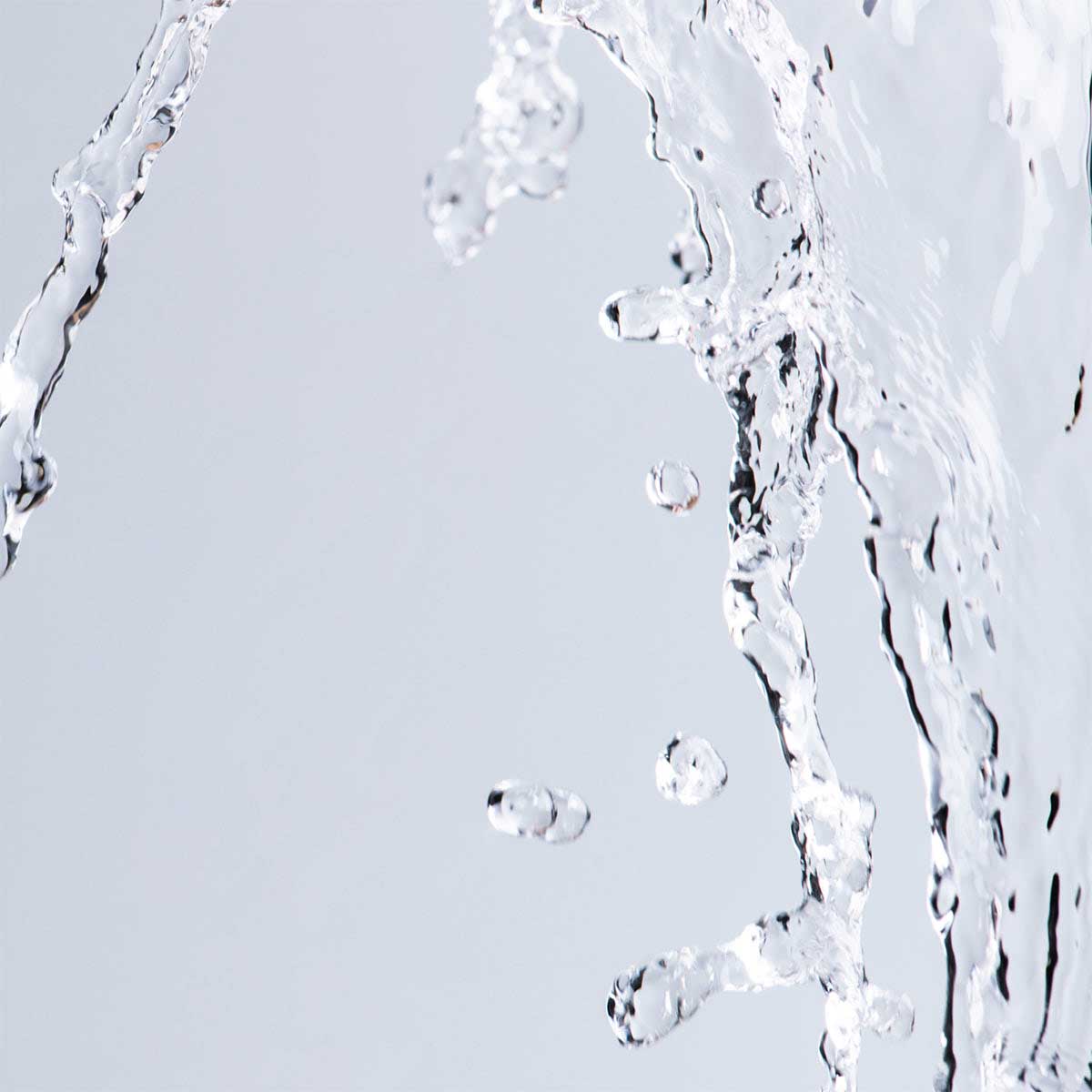 A close up of Alteya Organics Hydrating Flower Toner Luminous Rose splashing on a white background.