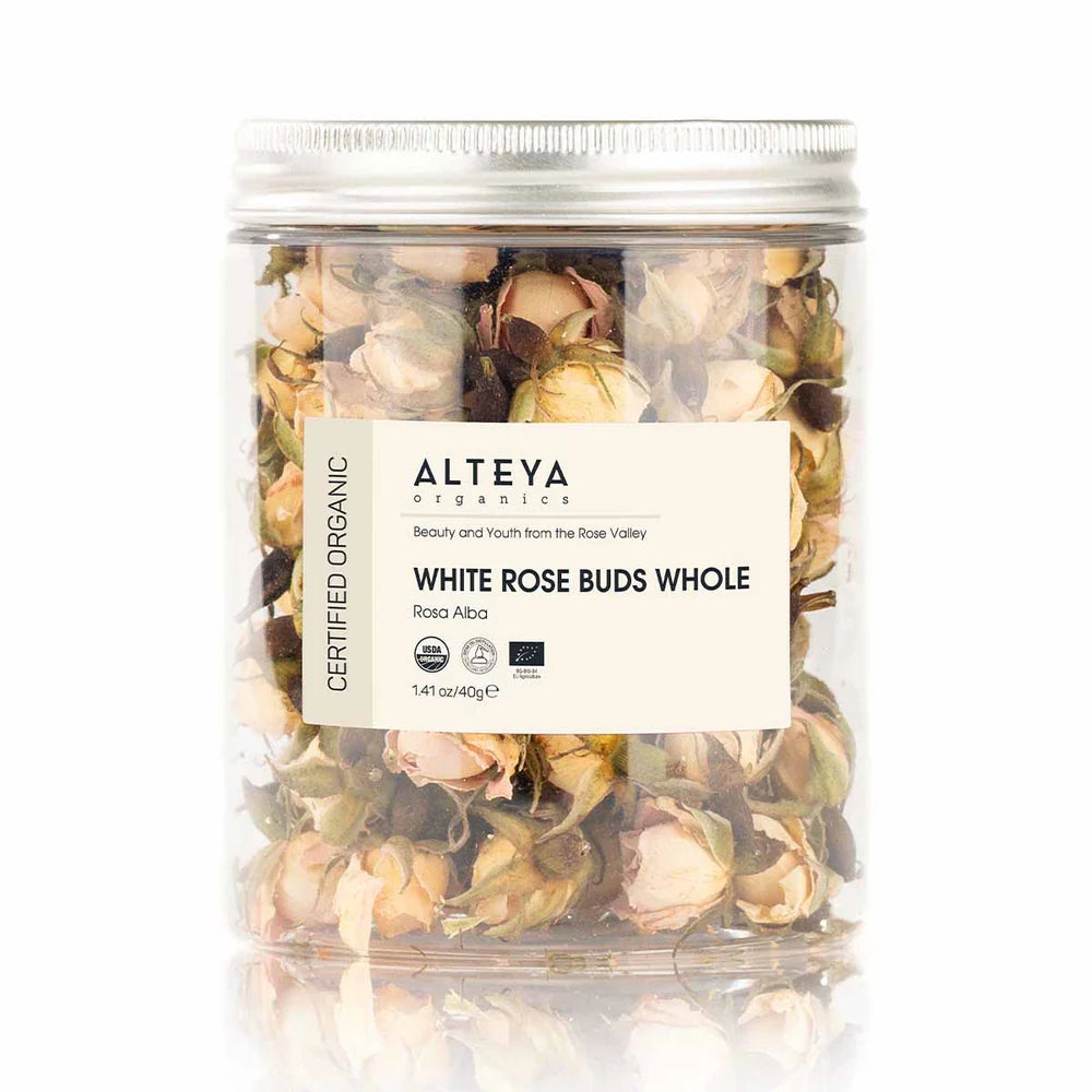 A clear jar labeled "Organic Whole Rose Buds Alba 1.41 Oz/40g" contains organic Rosa Alba rose buds, highlighting their premium quality against a stark white background.