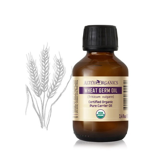 A nourishing bottle of Organic Wheat Germ Carrier oil /Triticum vulgare/ from Alteya Organics next to a wheat seed.