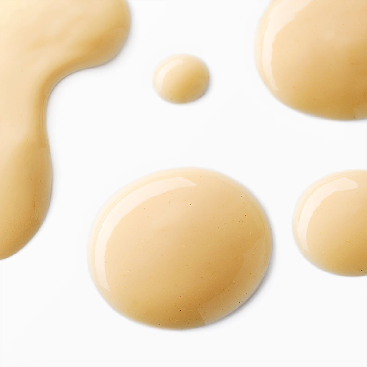 A group of beige Bio Damascena Rose Otto Regenerating Concentrate liquids on a white background, promoting cell regeneration with Alteya Organics regenerating concentrate.