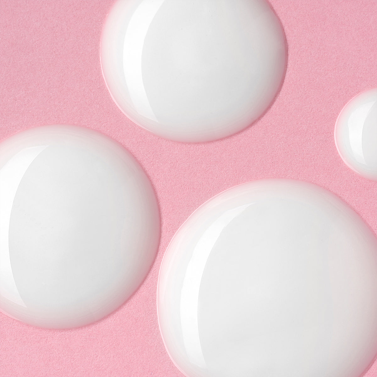 A cluster of white circles on a pink background, reminiscent of the Iridescent Light Serum Luminous Rose by Alteya Organics, a skin hydrating and moisturizing serum.